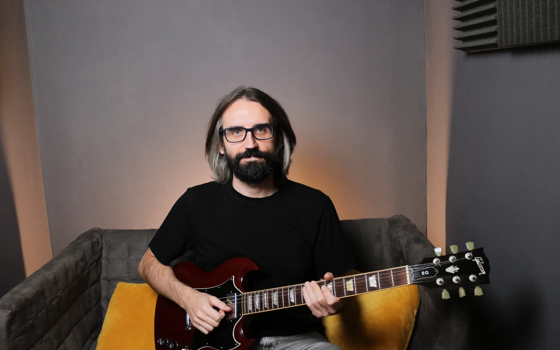 Profesor de guitarra tocando guitarra eléctrica en el estudio